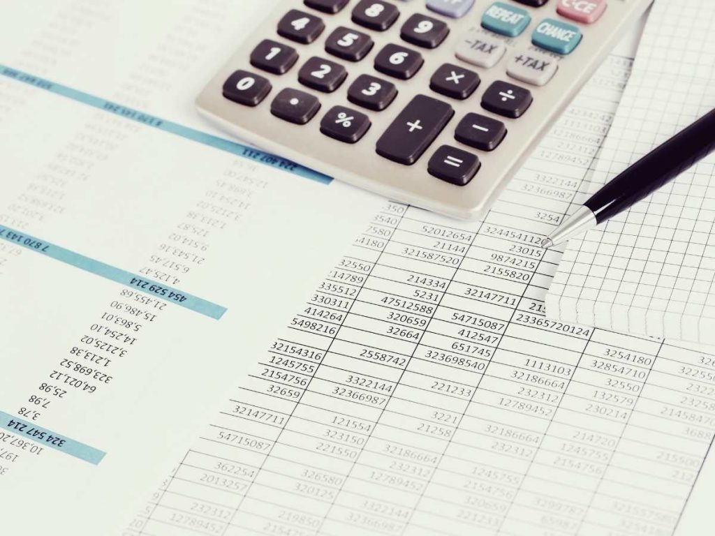 Calculadora e documentos financeiros sobre a mesa, título "Doutorado Preço".