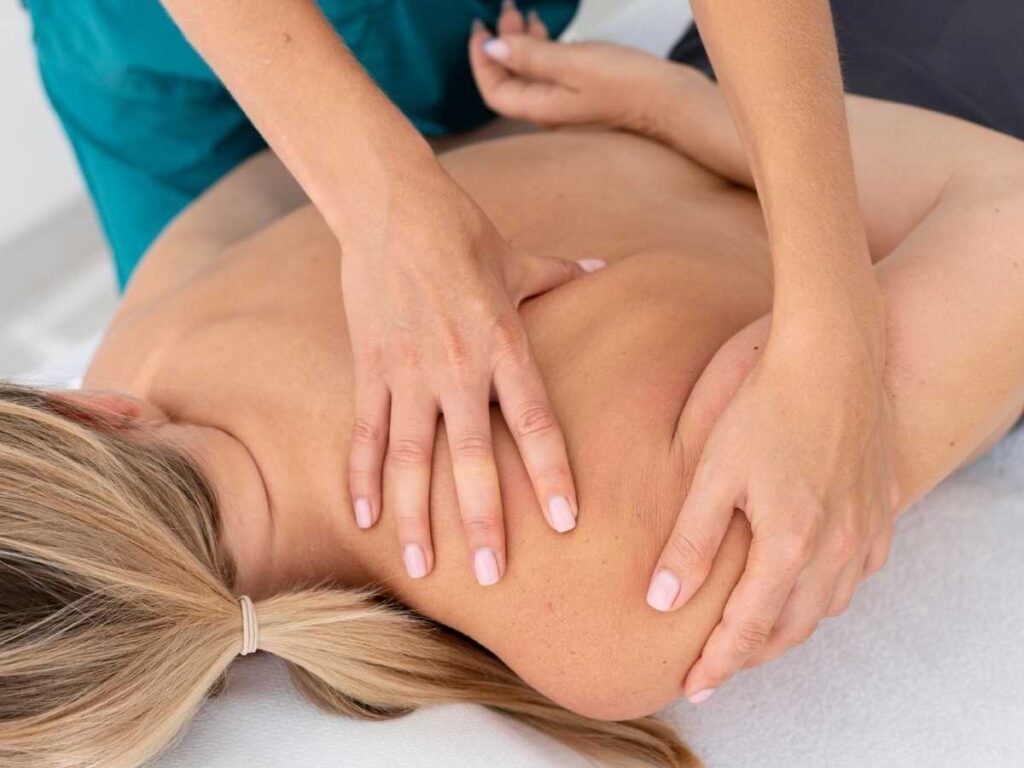 Fisioterapeuta aplicando bandagem funcional em paciente, representando pesquisa prática de tese de mestrado em fisioterapia.