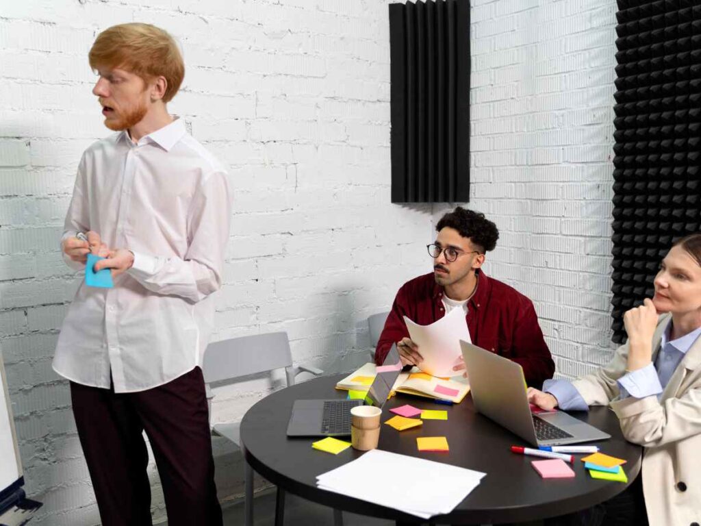 Pessoa apresentando ideias em reunião acadêmica, ilustrando o desenvolvimento da metodologia de uma tese de doutorado.